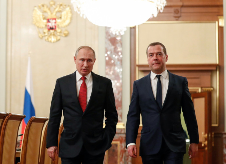 Russian President Putin and Prime Minister Medvedev speak before a meeting with government members in Moscow