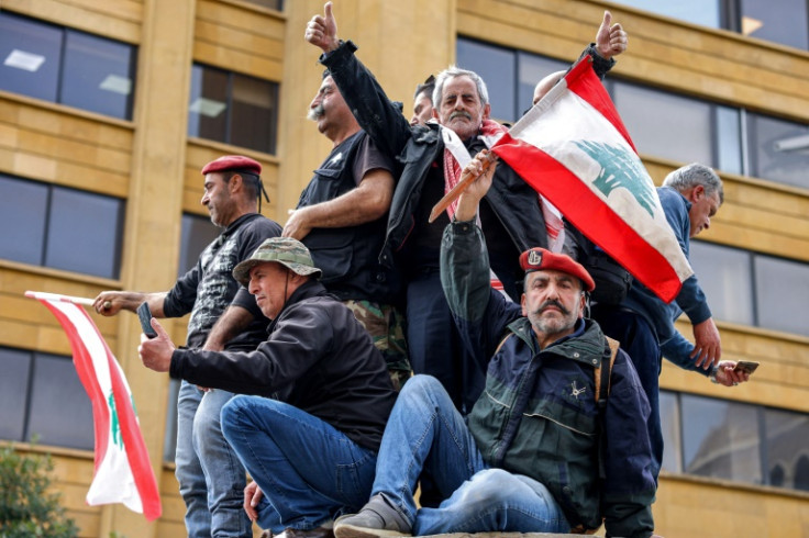 Protesters wave Lebanon's flag during a demonstration by retired army and security forces veterans on Wednesday, demanding inflation-adjustments to their pensions