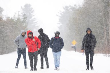 Asylum seekers cross into Canada from Roxham Road in Champlain New York
