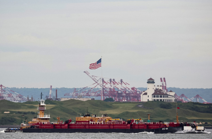 A tug boat pushes an oil barge through New York Harbor