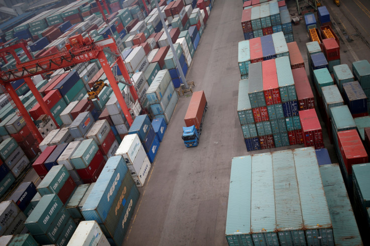 A truck drives between shipping containers at a container terminal at Incheon port in Incheon