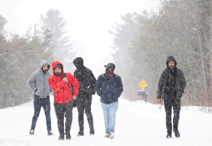 Asylum seekers cross into Canada from Roxham Road in Champlain New York