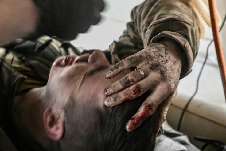 A wounded Ukrainian serviceman is carried away from the front line near Bakhmut in east Ukraine