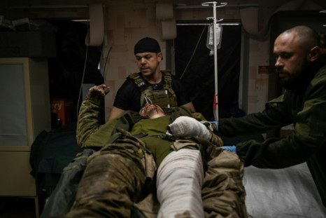 A wounded Ukrainian serviceman receives treatment at a stabilisation point near Bakhmut