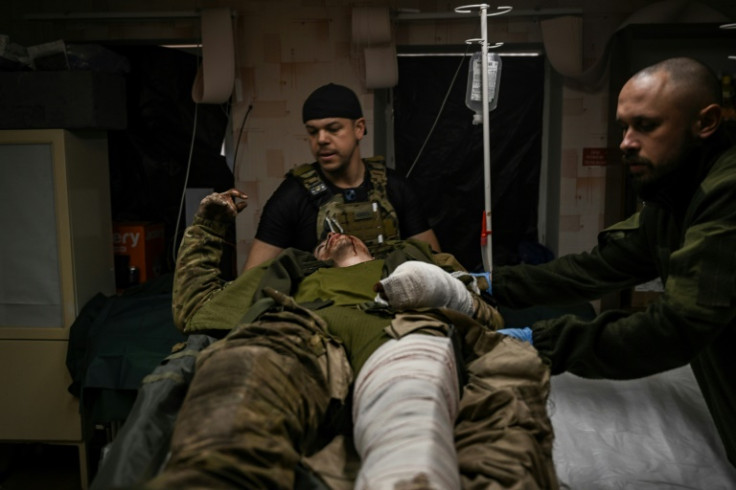 A wounded Ukrainian serviceman receives treatment at a stabilisation point near Bakhmut