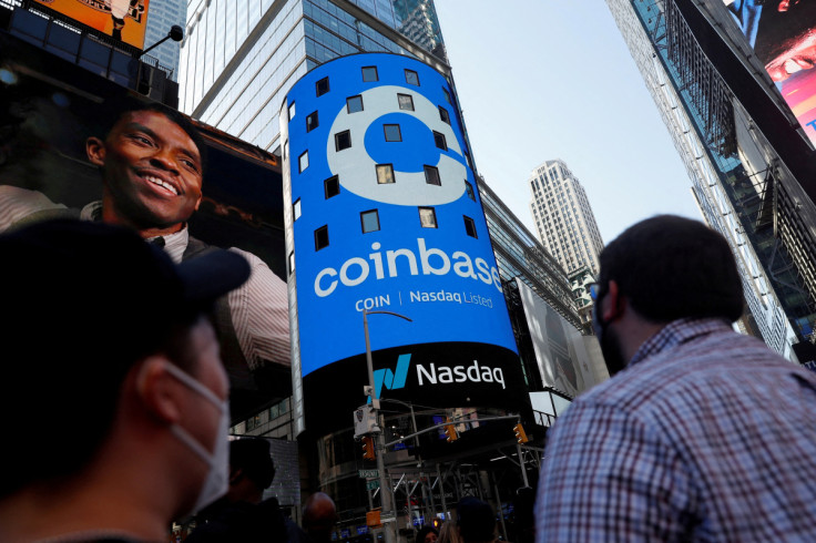 People watch as the logo for Coinbase Global Inc, the biggest U.S. cryptocurrency exchange, is displayed on the Nasdaq MarketSite jumbotron at Times Square in New York