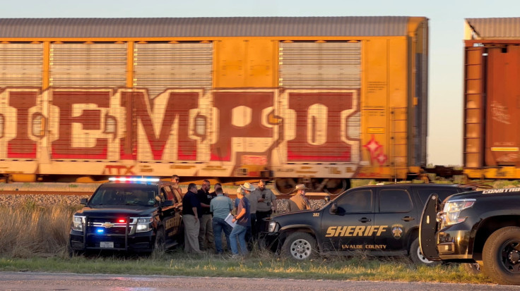 Police work after two migrants suffocated to death aboard a freight train that got derailed, in Uvalde