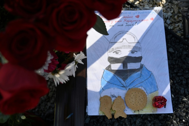 Mourners leave sweets, cigarettes and children's drawings