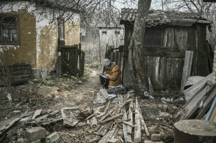 A woman keeps notes and uses her smartphone in the town of Chasiv Yar in eastern Ukraine