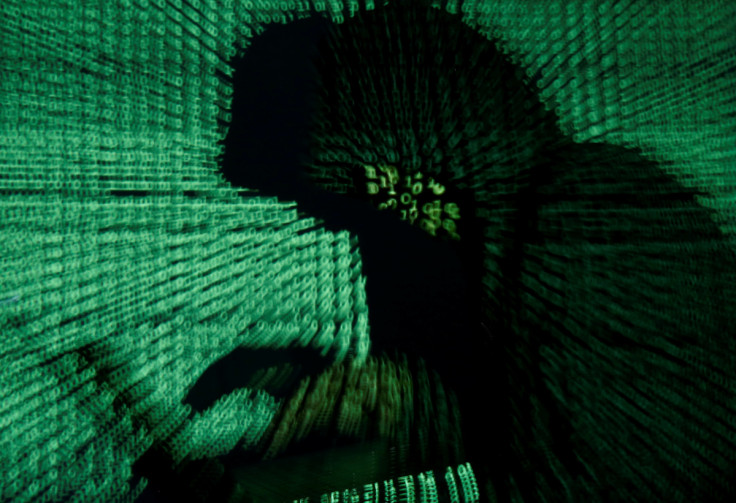 Man holds laptop computer as cyber code is projected on him in this illustration picture