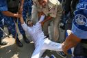 Police detain a supporter of India's Congress party during a protest against the conviction of party leader Rahul Gandhi in a criminal defamation case