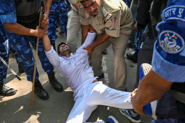 Police detain a supporter of India's Congress party during a protest against the conviction of party leader Rahul Gandhi in a criminal defamation case