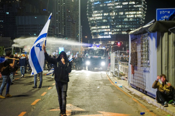 Security forces use a water cannon to disperse the people attending a demonstration against Israeli Prime Minister Benjamin Netanyahu and his nationalist coalition government's plan for judicial overhaul, in Tel Aviv