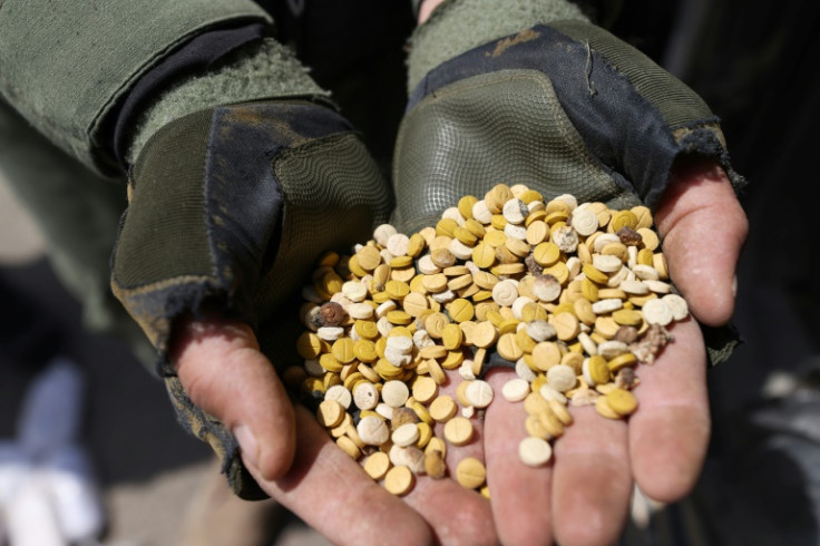 Fighters affiliated with Syria's Hayat Tahrir al-Sham rebel group display drugs seized at a checkpoint in the  countryside of the northern Aleppo province in April 2022