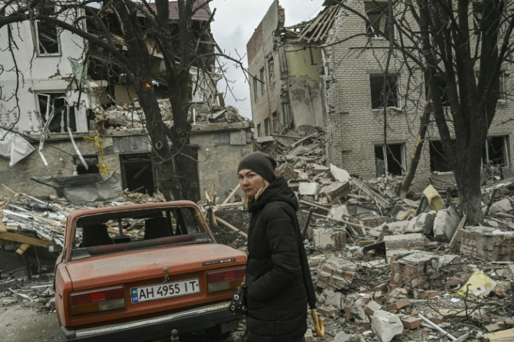 A woman stands in front of a destroyed building after a deadly Russian strike in the Ukrainian city of Sloviansk