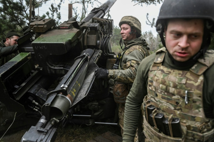 Ukrainian servicemen load an artillery unit before firing at Russian positions in east Ukraine