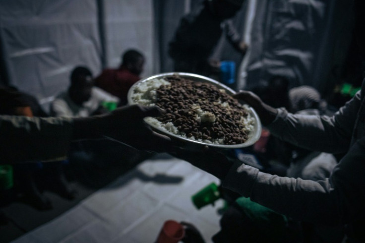 As night falls, Muslim worshippers pass around a platter of rice and beans