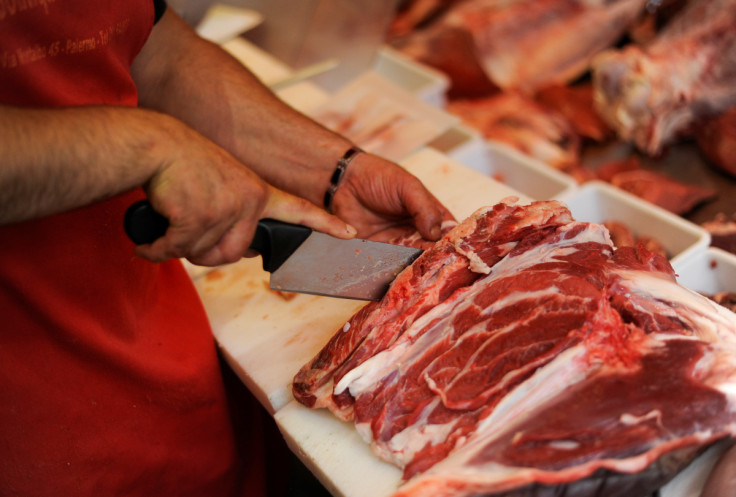 A butcher cuts meat at a meat shop in the Ballaro market in downtown Palermo