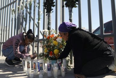 Activists and migrants lay flowers outside a detention center in northern Mexico where dozens of migrants died in a fire