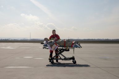 A wounded soldier is wheeled to medical evacuation plane in eastern Poland