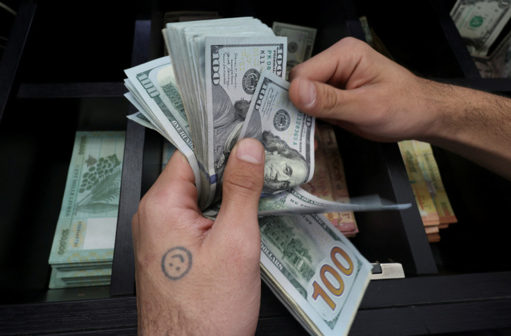 A money exchange vendor counts U.S. dollar banknotes at a shop in Beirut