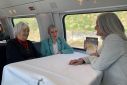 Three women who are members of the association Senior Women for Climate Protection chat on a train ride from Switzerland to the European Court of Human Rights in Strasbourg
