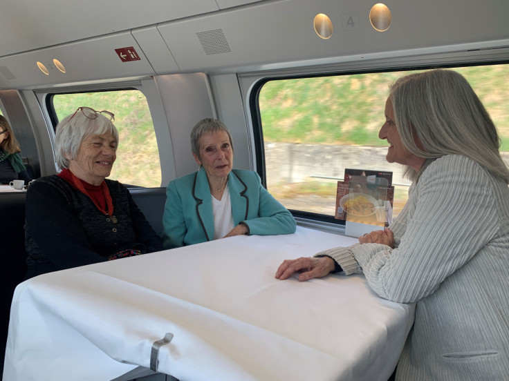 Three women who are members of the association Senior Women for Climate Protection chat on a train ride from Switzerland to the European Court of Human Rights in Strasbourg