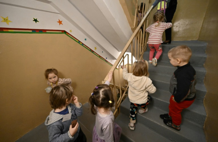 Children walk out of an air-raid shelter in a kindergarten cellar after an all-clear signal in Kyiv