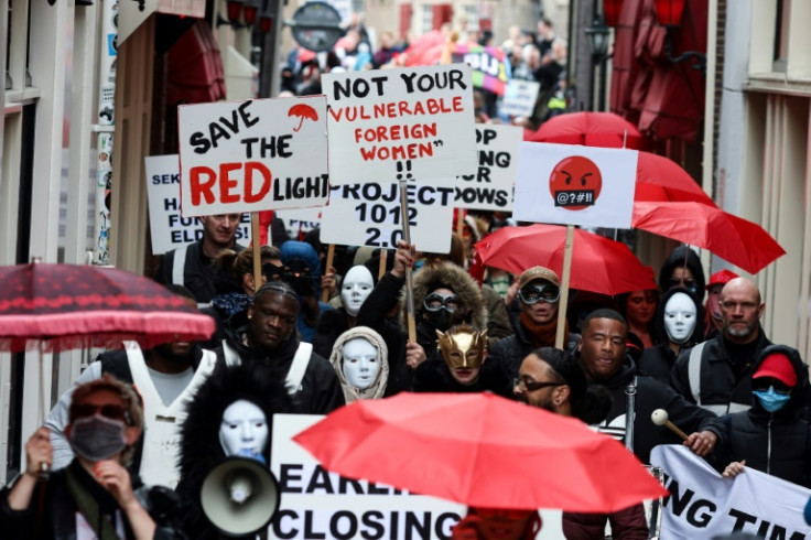 Dozens of sex workers, many wearing masks, protested in Amsterdam's red light district