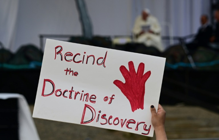 A protest sign is held up during a visit to Canada's subarctic region by Pope Francis in mid- 2022