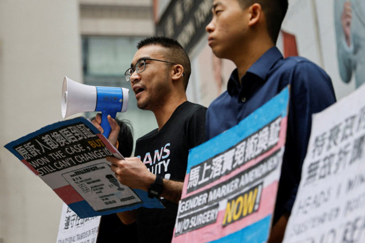Henry Tse and applicants hold placards to protest for a gender change on their identity cards to be processed after winning a landmark court case in February, in Hong Kong
