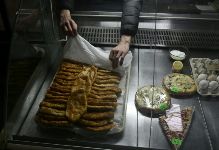Store manager Artem, 30, sets a tray of potato-filled pies