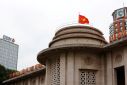 A Vietnamese flag flies atop the State Bank building in central Hanoi