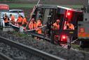 Train staff inspect the first derailment near the lakeside town of Luscherz, northwest of Bern