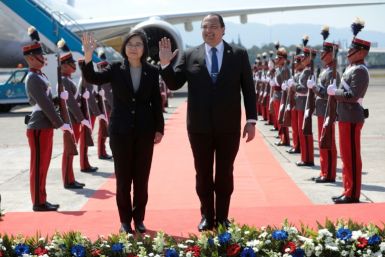 A photo released by Guatemala's Presidency shows Taiwan President Tsai Ing-wen (L) and Guatemala's Foreign Minister Mario Bucaro waving during a welcoming ceremony at an air force base in Guatemala City on March 31, 2023