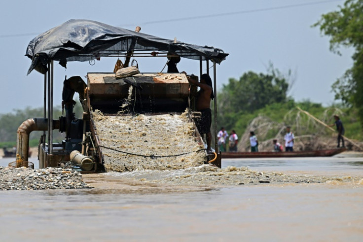 Miners search for gold using a dredger in Colombia's Nechi river on March 23, 2023