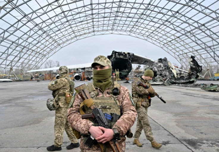 Ukrainian servicemen stand guard during a donation ceremony of some ten off-road vehicles mounted with machine guns