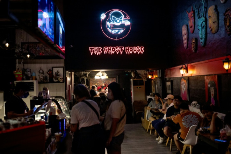 Guests listen to the live show of Ghost Radio at its cafe in Bangkok