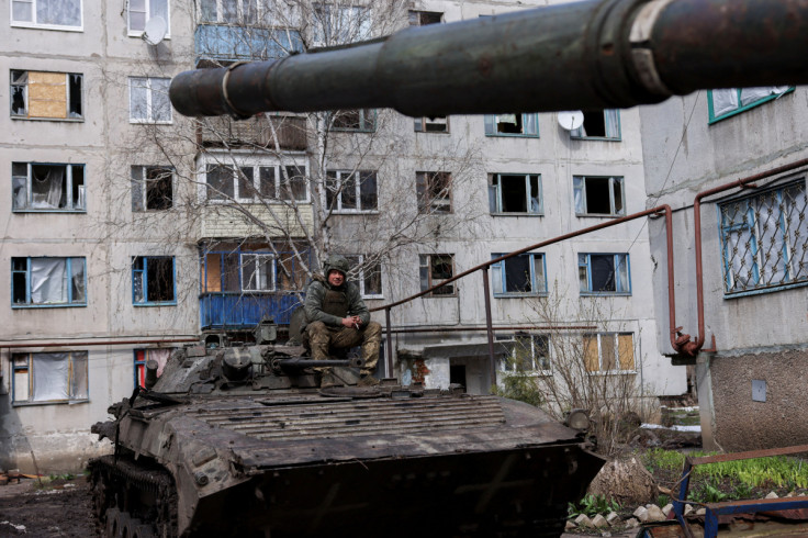 An Ukrainian serviceman sits atop an infantry fighting vehicle, near the bombed-out eastern city of Bakhmut