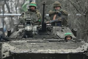 Ukrainian servicemen ride on an infantry fighting vehicle near the battleground city of Bakhmut on April 3, 2023