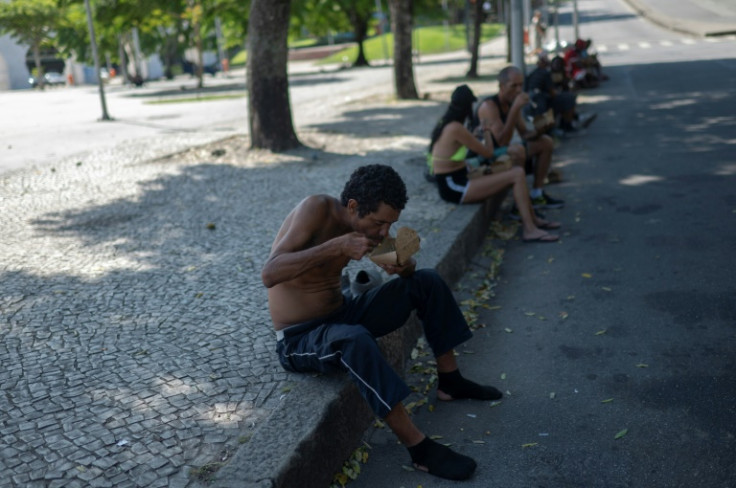 A homeless man eats a meal donated by Brazilian chef Carlos Alberto da Silva, known as Nego Breu, and his team in the Lapa neighborhood in Rio de Janeiro