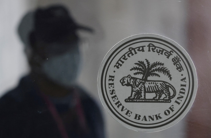 A man walks behind the Reserve Bank of India (RBI) logo inside its headquarters in Mumbai