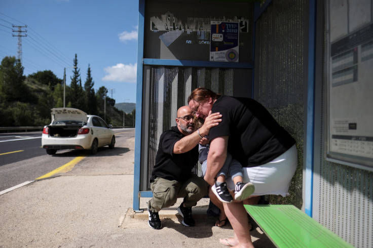 People react as siren sounds following incoming rockets from Lebanon to Israel near Shlomi, northern Israel