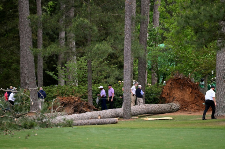 Course officials look over fallen trees on the 17th hole during the second round of the Masters at Augusta National Golf Club on Friday