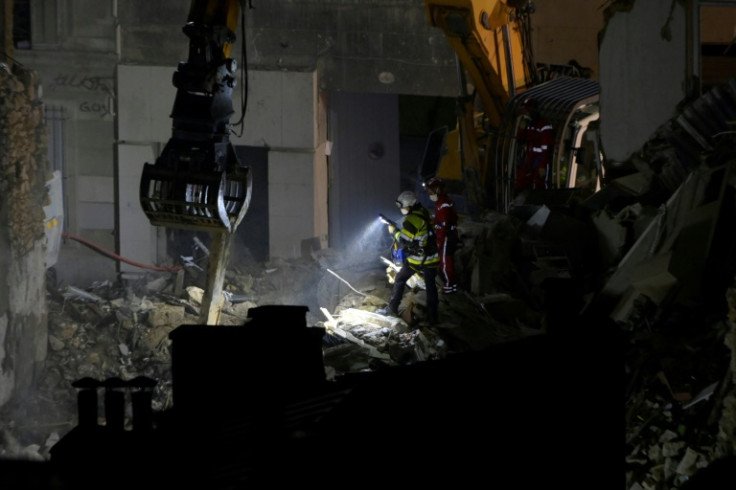 Emergency workers continued rescue operations at night with the help of a crane and floodlights