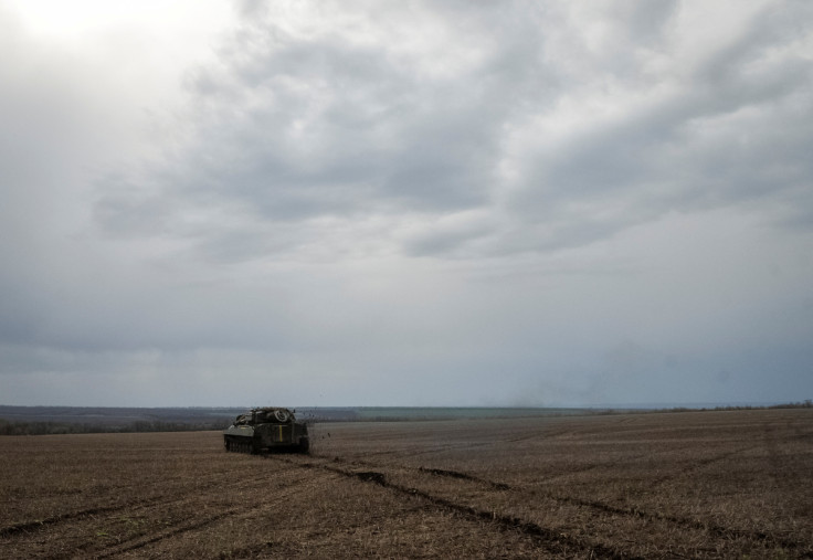 Ukrainian service members ride a self-propelled howitzer near the front line city of Bakhmut