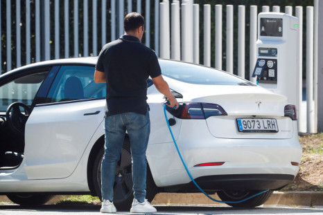 A man removes a cable after charging a Tesla electric car in Sant Cugat del Valles, near Barcelona