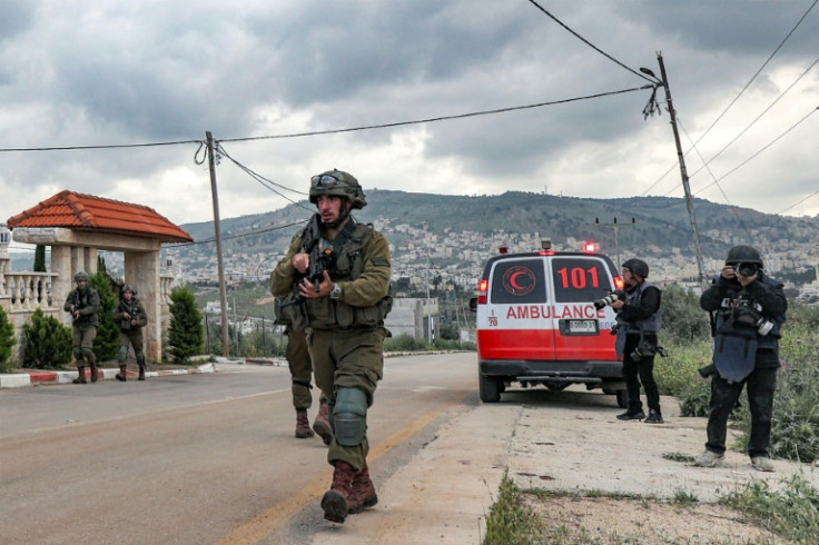 Israeli troops and journalists near an ambulance in Elon Moreh settlement, the occupied West Bank