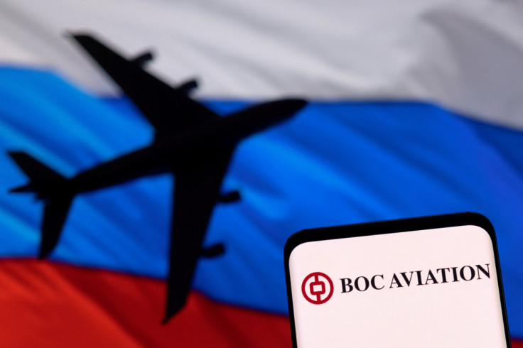Illustration shows BOC Aviation logo displayed in front of the model of an airplane and a Russian flag