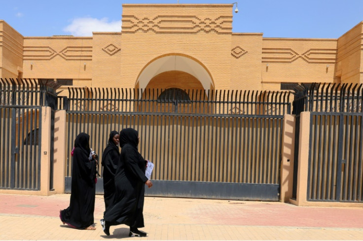 Women walk past the closed Iranian embassy in the Saudi capital Riyadh